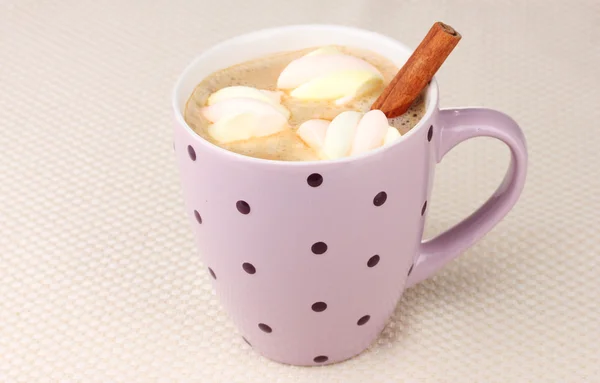 Tasse Cappucino mit Marshmallows und Zimt auf beigem Hintergrund — Stockfoto