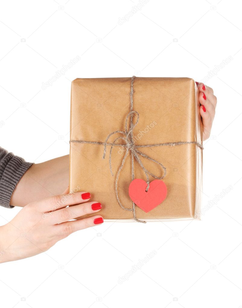 Parcel with blank heart-shaped label in woman's hand isolated on white