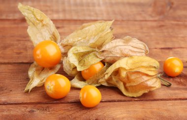 Physalis heap on wooden background clipart