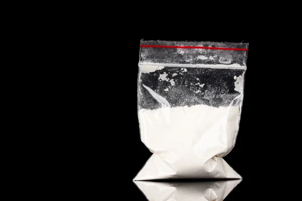 Кокаин в упаковке на черном фоне — стоковое фото