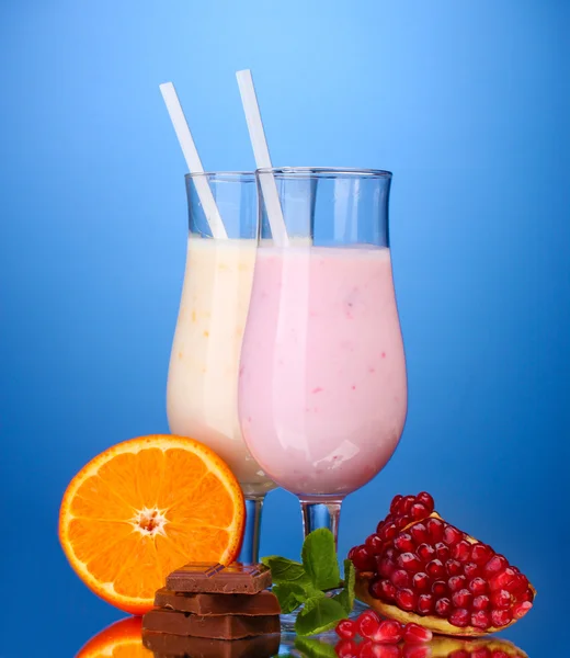 Frullati di latte con frutta e cioccolato su sfondo blu — Foto Stock