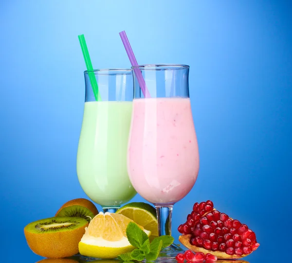 Batidos de leche con frutas sobre fondo azul — Foto de Stock