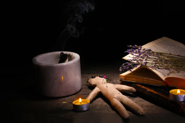 Muñeco vudú en una mesa de madera a la luz de las velas —  Fotos de Stock