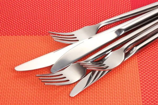 Tenedores y cuchillos sobre un mantel rojo —  Fotos de Stock