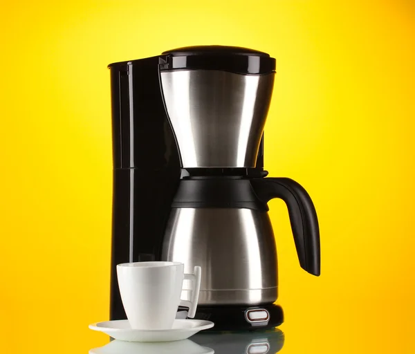 Kaffeemaschine mit weißer Tasse auf gelbem Hintergrund — Stockfoto