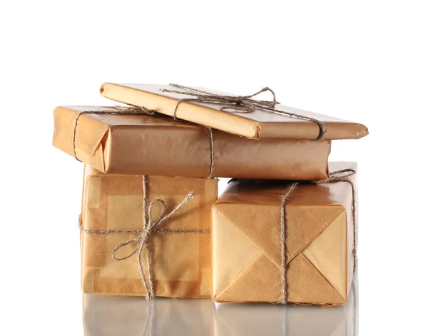 Muchos paquetes envueltos en papel marrón atado con cordel aislado en blanco — Foto de Stock