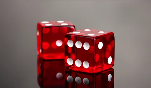 Red dices on grey background — Stock Photo, Image