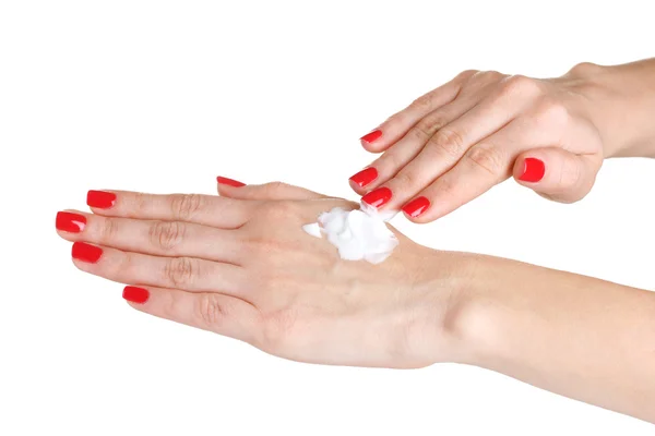Mão feminina com manicure aplicando creme na mão isolado no branco — Fotografia de Stock