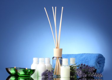 Bottle of air freshener, lavander, towel and candles on blue background clipart