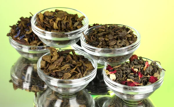 Verschiedene Arten von grünem und schwarzem Tee auf grünem Hintergrund — Stockfoto