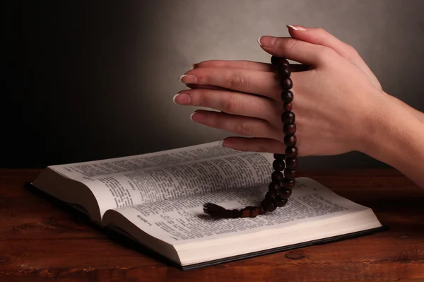 Handen gevouwen in gebed over open Russische Heilige Bijbel — Stockfoto