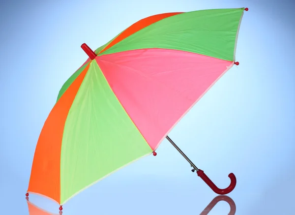 Multi-colored umbrella on blue background — Stock Photo, Image
