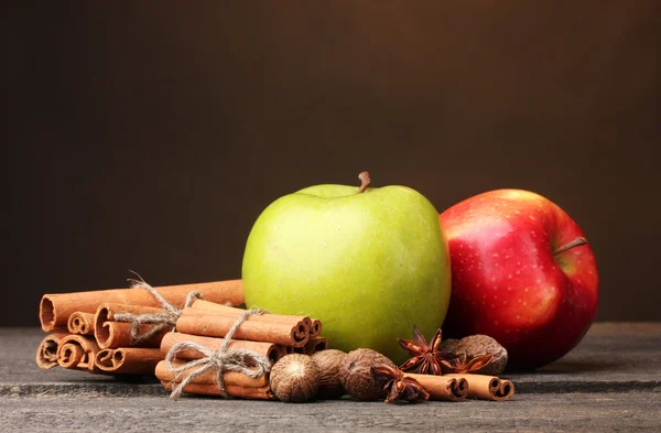 Stock image Cinnamon sticks,apples nutmeg and anise on wooden table on brown background