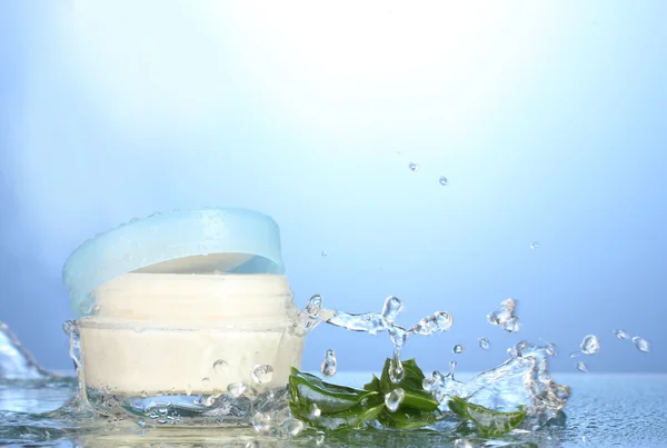 stock image Opened jar of cream in water splash on blue background