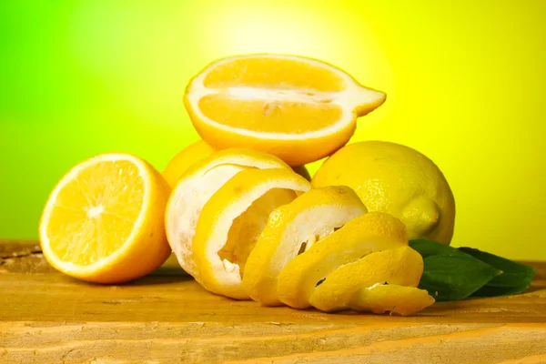 成熟柠檬与绿色背景上的木桌上的叶子 — 图库照片