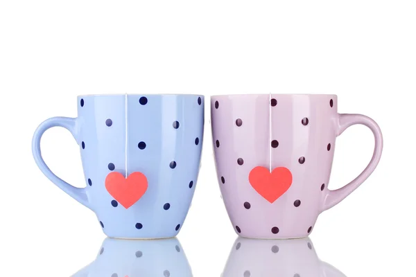 Duas xícaras e sacos de chá com rótulo vermelho em forma de coração isolado no branco — Fotografia de Stock