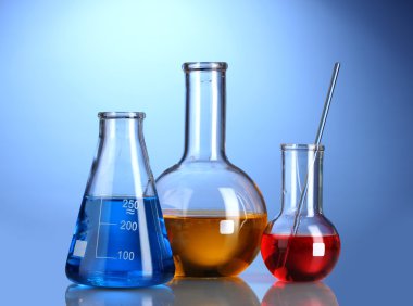 Three flasks with color liquid with reflection on blue background clipart