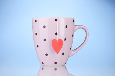 pembe Kupası ve çay poşeti ile mavi arka plan üzerinde kırmızı kalp şeklinde etiket