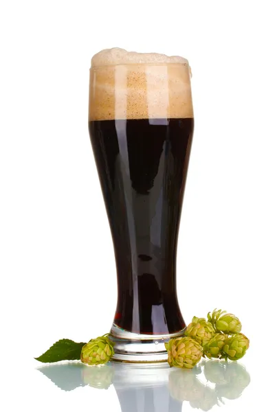 Cerveja escura em um copo e salto verde isolado em branco — Fotografia de Stock