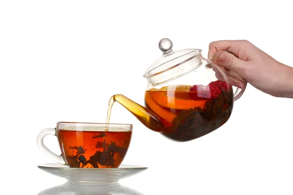 Glas Teekanne Gießen schwarzer Tee in Tasse isoliert auf weiß — Stockfoto