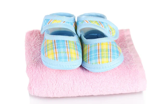Modré dětské botičky na růžový ručník izolovaných na bílém — Stock fotografie