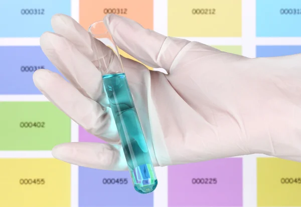 색상 샘플 배경 손에 파란 액체 튜브 — 스톡 사진