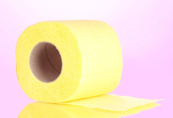 Żółty rolka papieru toaletowego na różowym tle — Zdjęcie stockowe