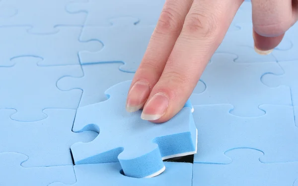 Hand verzamelen van een deel van een puzzel — Stockfoto