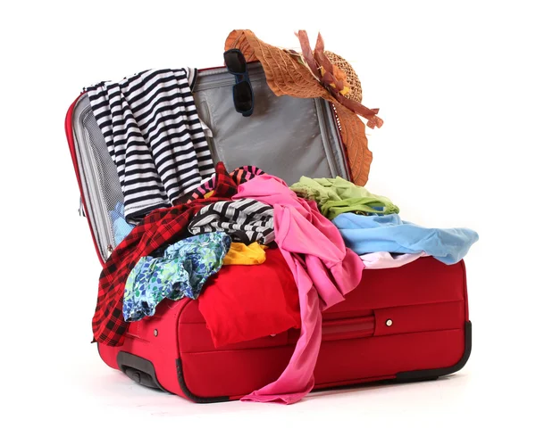 Valigia rossa aperta con indumenti isolati su un bianco — Foto Stock