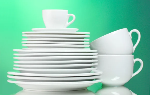 Platos, vasos y vasos limpios sobre fondo verde — Foto de Stock
