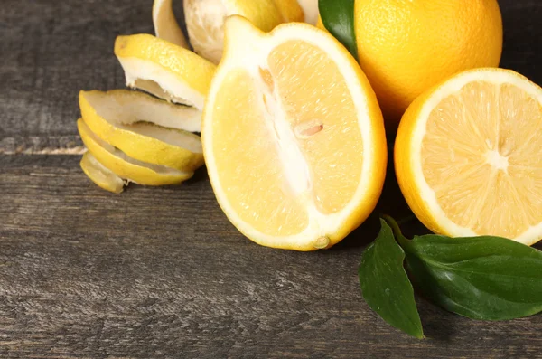 Reife Zitronen mit Blättern auf Holztisch — Stockfoto
