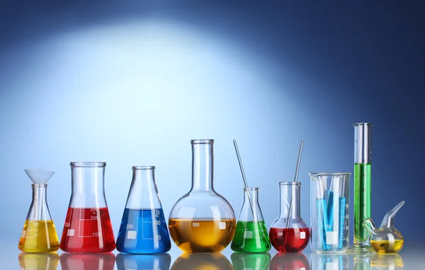 Різні лабораторні скляні посуд з кольоровою рідиною і з відображенням на Блю — стокове фото