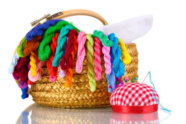 Bright threads for needlework and fabric in a wicker basket clipart