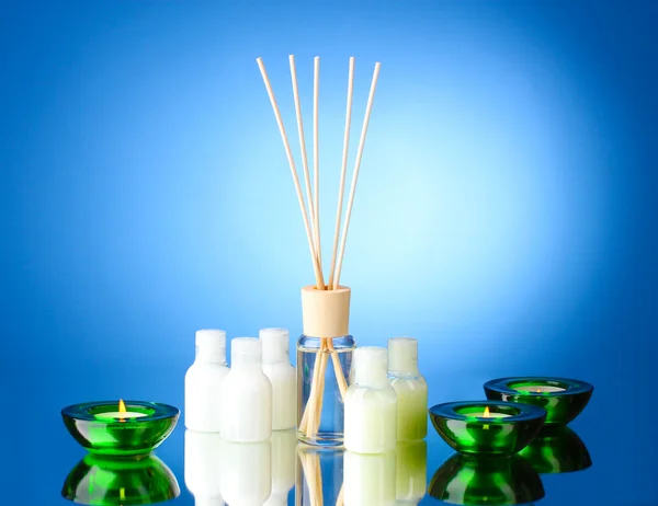 Garrafa de purificador de ar e velas no fundo azul — Fotografia de Stock