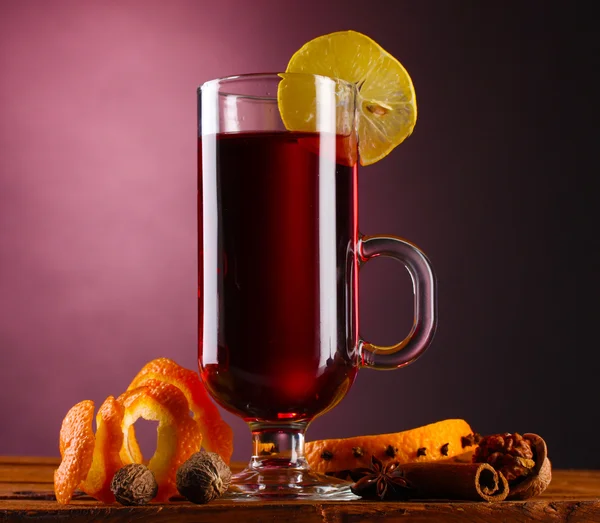 Glühwein im Glas, Gewürz und Zitrone auf violettem Hintergrund — Stockfoto