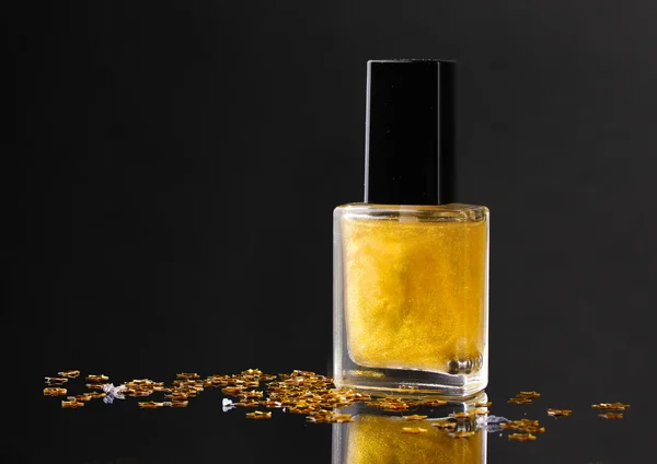 Esmalte de uñas dorado sobre fondo negro — Foto de Stock