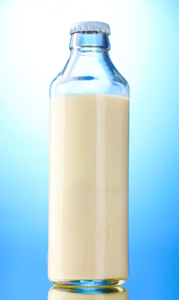 Bottiglia di latte su fondo blu — Foto Stock