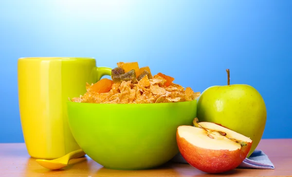 Smakelijke cornflakes in groene kom, appels en glas melk op houten tafel op — Stockfoto