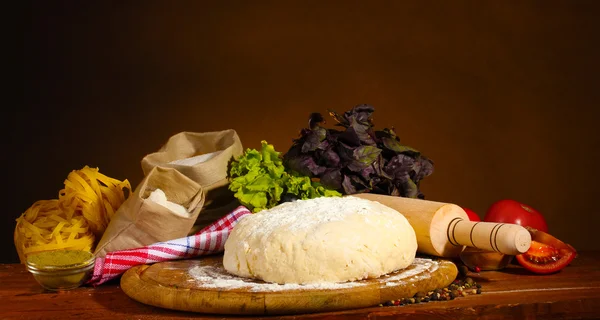 Ингредиенты для домашней пиццы на деревянном столе на коричневом фоне — стоковое фото