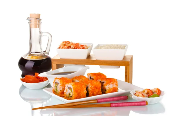 Delizioso sushi su piatto, bacchette, salsa di soia, pesce e gamberetti isolati — Foto Stock