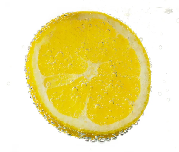 Schijfje citroen in het water met bubbels — Stockfoto