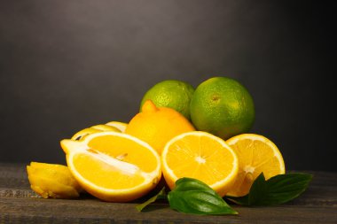 Olgun limon ve limes yapraklar gri arka plan üzerinde ahşap tablo