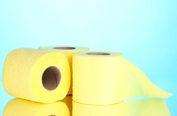 Rotoli gialli di carta igienica su sfondo blu — Foto Stock