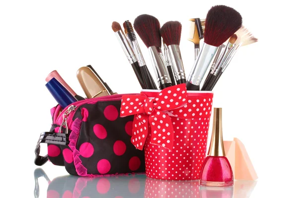 Vetro rosso con pennelli e borsa per il trucco con cosmetici isolati su bianco — Foto Stock