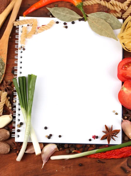Ноутбук для рецептов и специй на деревянном столе — стоковое фото