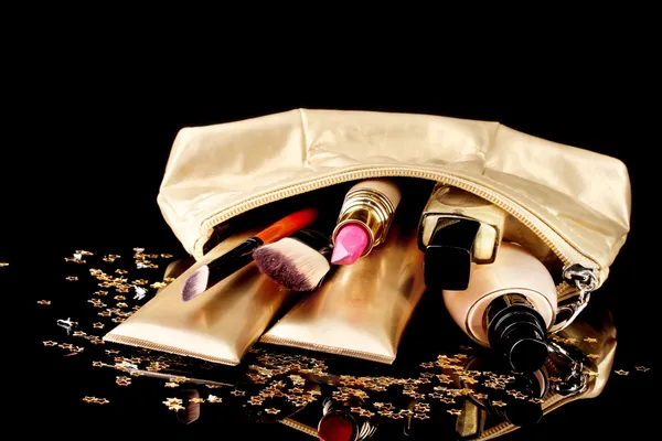 Indah tas makeup emas dan kosmetik terisolasi pada hitam — Stok Foto
