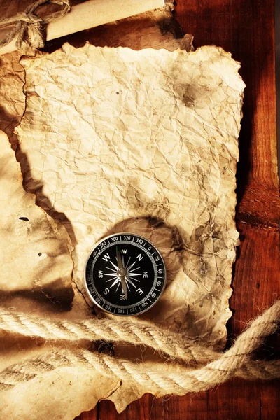 Старий папір, компас і мотузка на дерев'яному столі — стокове фото