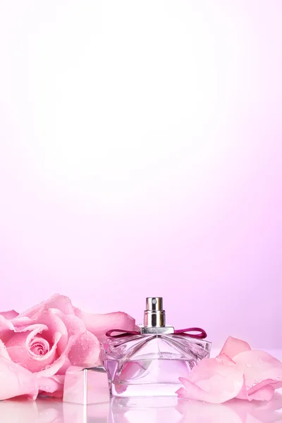 Botella de perfume y rosa rosa sobre rosa —  Fotos de Stock