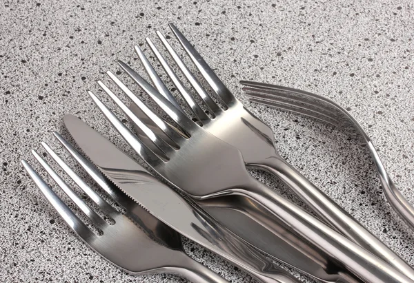 Πιρούνια και μαχαίρια στο μαρμάρινο τραπέζι — Φωτογραφία Αρχείου