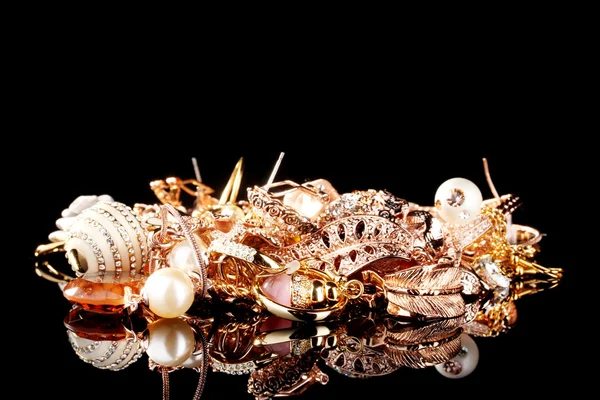 Různé zlaté šperky na černém — Stock fotografie